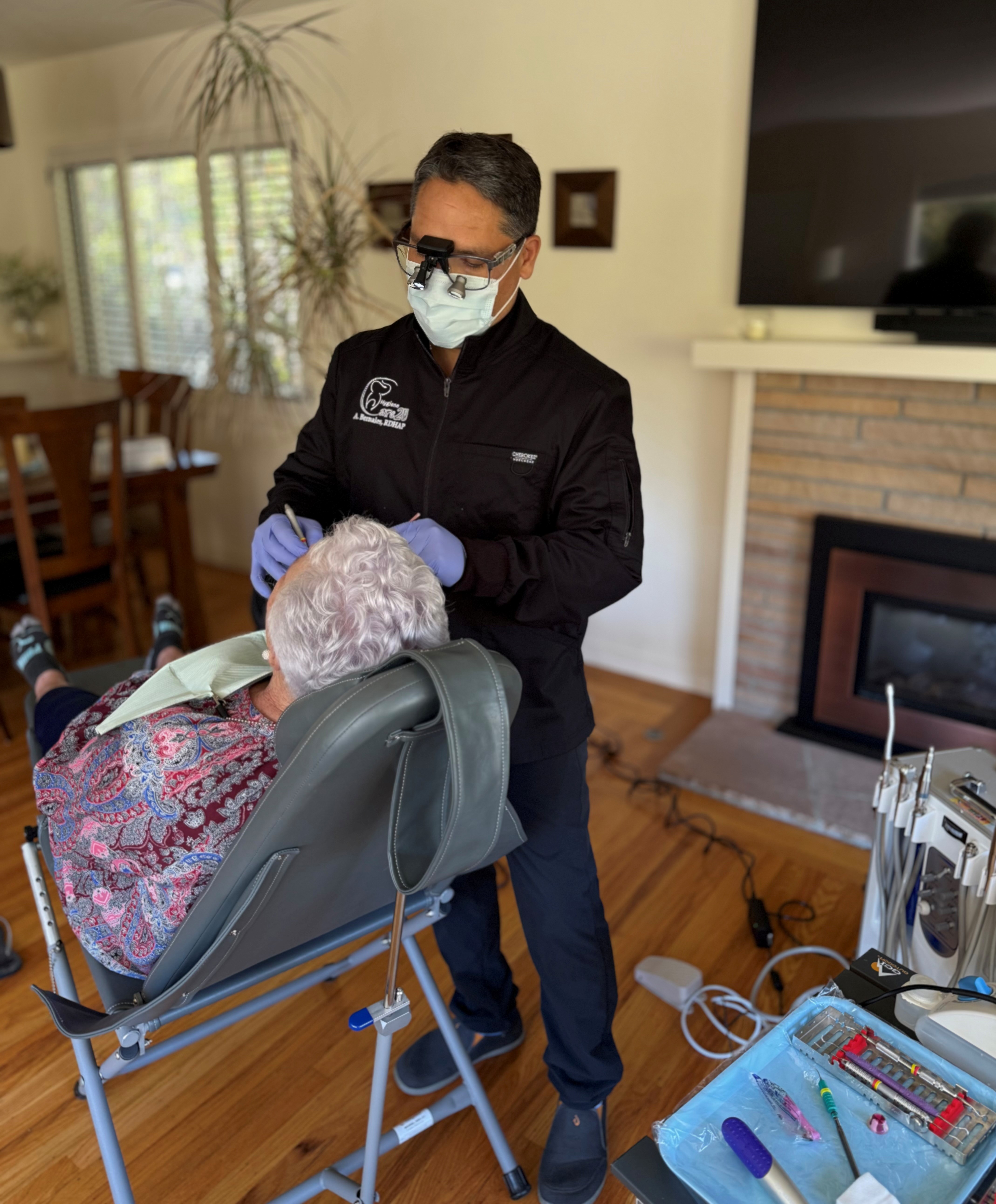 Alan Bernales, RDHAP, providing dental hygiene care to a patient in their home
